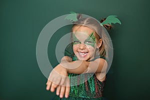 A cheerful Girl with a painted face with dragon image laughs looking at camera