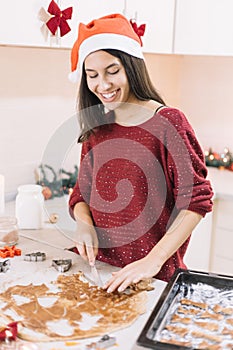 Cheerful girl performing Christmas cuttings in gingerbread dow.