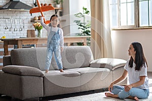 Cheerful girl playing with her mother at hom