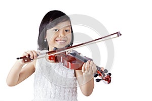 Cheerful girl playing violin in the studio