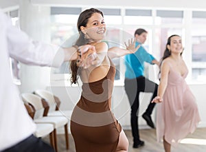 Cheerful girl rehearsing upbeat jive with partner in dance studio photo