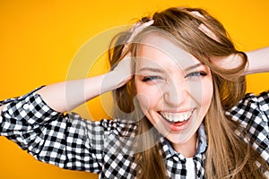 Cheerful girl in a shirt clutches her head with her hands laughing and looking at the camera photo