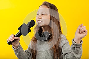 Cheerful girl sings into a microphone. Little Star, show business