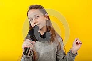 Cheerful girl sings into a microphone. Little Star, show business