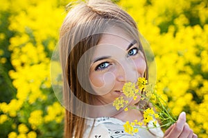 Cheerful girl smelling yellow wildflower