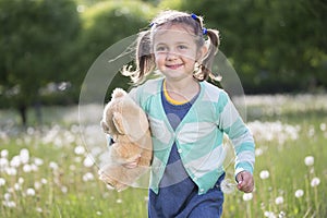 Cheerful girl on a summer meadow runs.