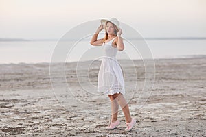 Cheerful girl at sunset in a white dress