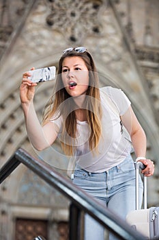 Cheerful girl is taking photo on her phone