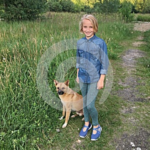 Cheerful girl walks with a dog mongrel