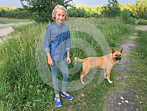 Cheerful girl walks with a dog mongrel