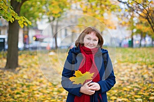 Cheerful girl in warm red scarf enjoying fall day