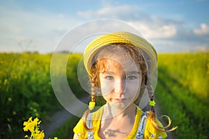 A cheerful girl in a yellow hat in a summer fiel. Children`s day, joy, sunny weather, holidays. A remedy for mosquitoes and