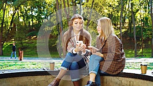 Cheerful girls using smartphones for online banking