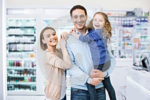 Cheerful glad family posing in drugstore and looking happy