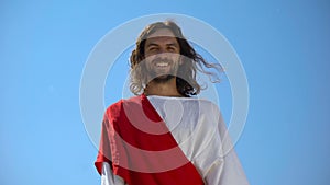 Cheerful god Jesus laughing into camera from heaven, concept to enjoy life