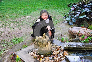 Cheerful Graduated Student Playing with Elephant Shape Fountain