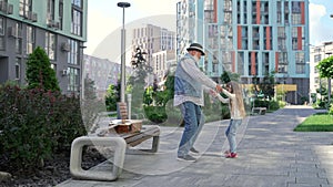 Cheerful granddaughter and grandpa dancin together