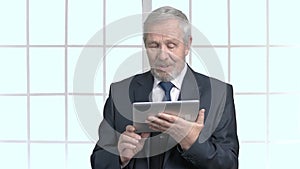 Cheerful grandfather in formal wear with tablet.