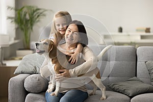 Cheerful grandmother and dog owner woman cuddling beagle
