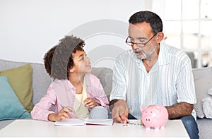 Cheerful Grandpa Calculating Money With His Little Grandson At Home