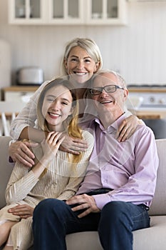 Cheerful grandparents and grandkid home family portrait
