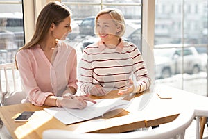 Cheerful granny family discussing business with her granddaughter