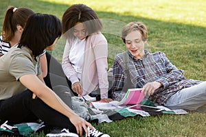 Cheerful group of multiethnic students studying outdoors.