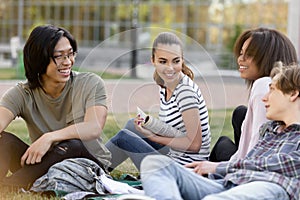 Cheerful group of multiethnic students studying outdoors.