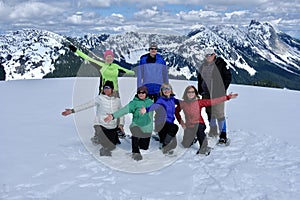 Cheerful group of people having fun and showshoeing in mountais near Vancouver.