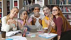 Cheerful group of students posing for camera at library