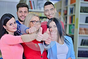 Cheerful group of students smiling at camera with thumbs up, success and learning concept