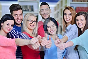 Cheerful group of students smiling at camera with thumbs up, success and learning concept