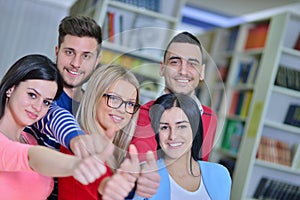 Cheerful group of students smiling at camera with thumbs up, success and learning concept
