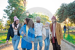 Cheerful group of students walking outdoors in the campus University college having fun together.