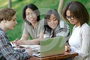 Cheerful group of young students sitting and studying