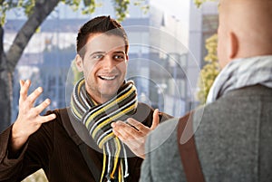 Cheerful guy gesturing to friend