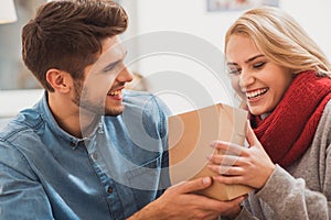 Cheerful guy giving present to girl