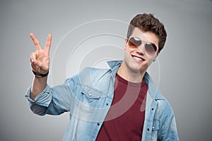 Cheerful guy making victory sign