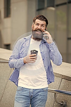 cheerful guy speak on smartphone outside. guy speak on smartphone in the street.