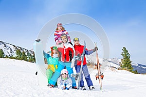 Cheerful guys standing with snowboards and skis