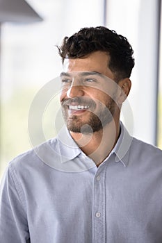 Cheerful handsome Arab professional man in formal shirt looking away