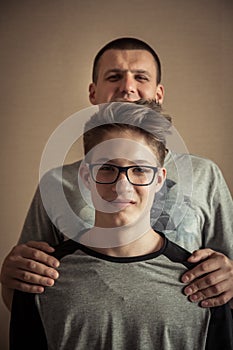 Cheerful handsome teenager boy with father as family portrait