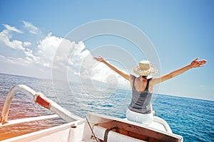 Cheerful and handsome woman traveling on the boat in ocean