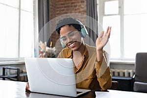 Cheerful happy African American hipster girl in headphones and glasses