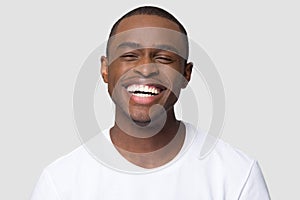 Cheerful happy african millennial man laughing isolated on studio background