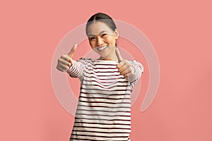 Cheerful Happy Asian Woman Showing Thumbs Up At Camera Over Pink Background