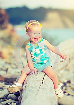 Cheerful happy baby girl laughing on walk in nature