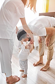 Cheerful happy baby laughing as her daddy making faces, entertaining her