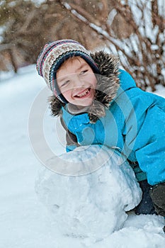 Cheerful happy boy playing in winter park,