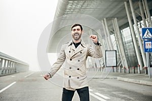 Cheerful and Happy Businessman is Actively Dancing on a Street . He`s Wearing a Grey Suit. Sunny Day